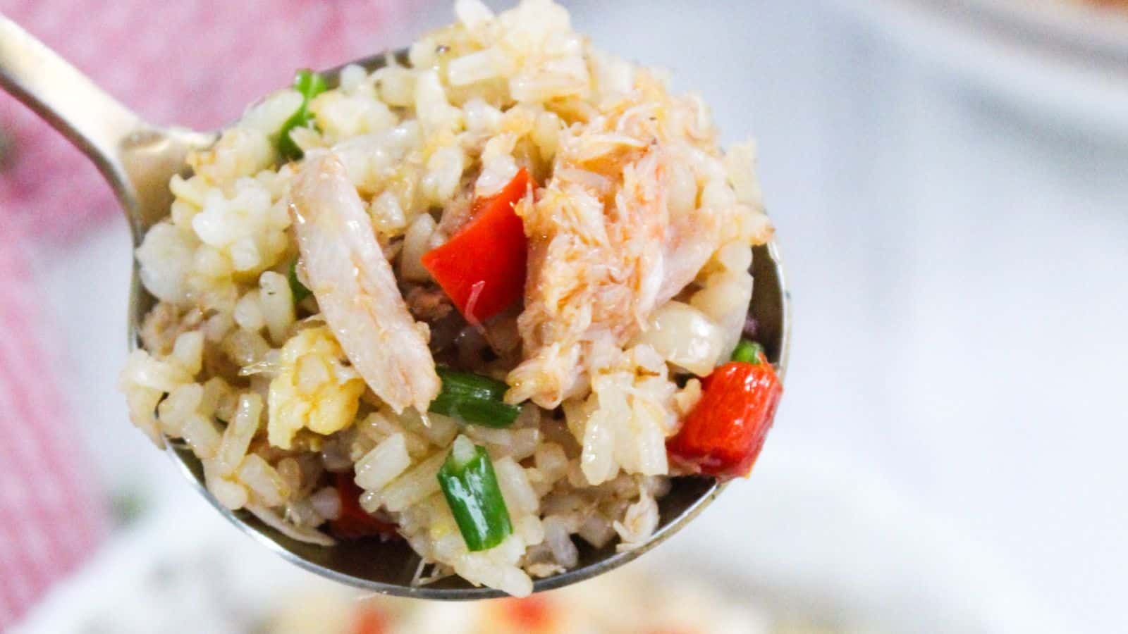 A bowl of fried rice with vegetables and crab meat.