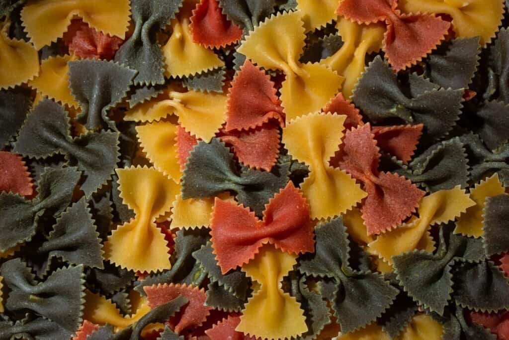 Dry uncooked colored farfalle pasta.