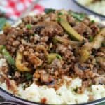 A plate with ground pork and vegetables on top of cauliflower rice.