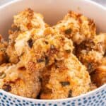 A bowl of golden brown popcorn chicken on a table.