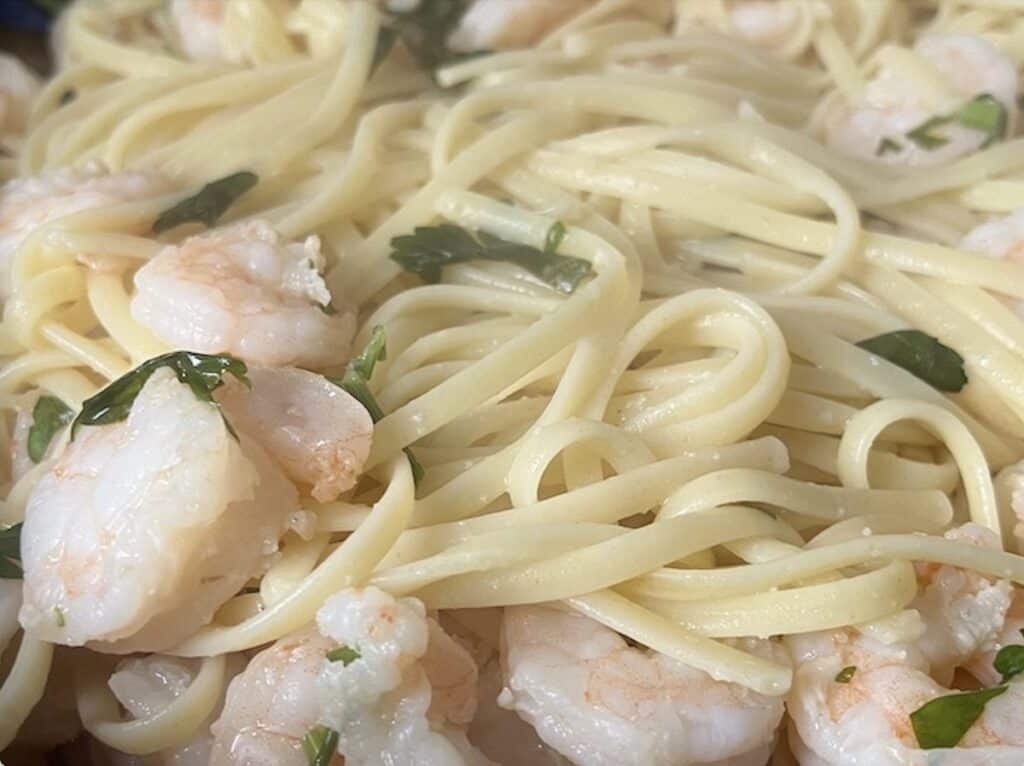 Close-up of linguine pasta with shrimp and parsley.