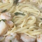 Close-up of linguine pasta with shrimp and parsley.