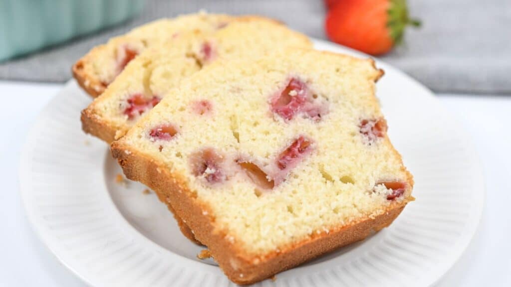 Slices of strawberry pound cake on a white plate, with visible chunks of strawberry and a golden-brown crust.