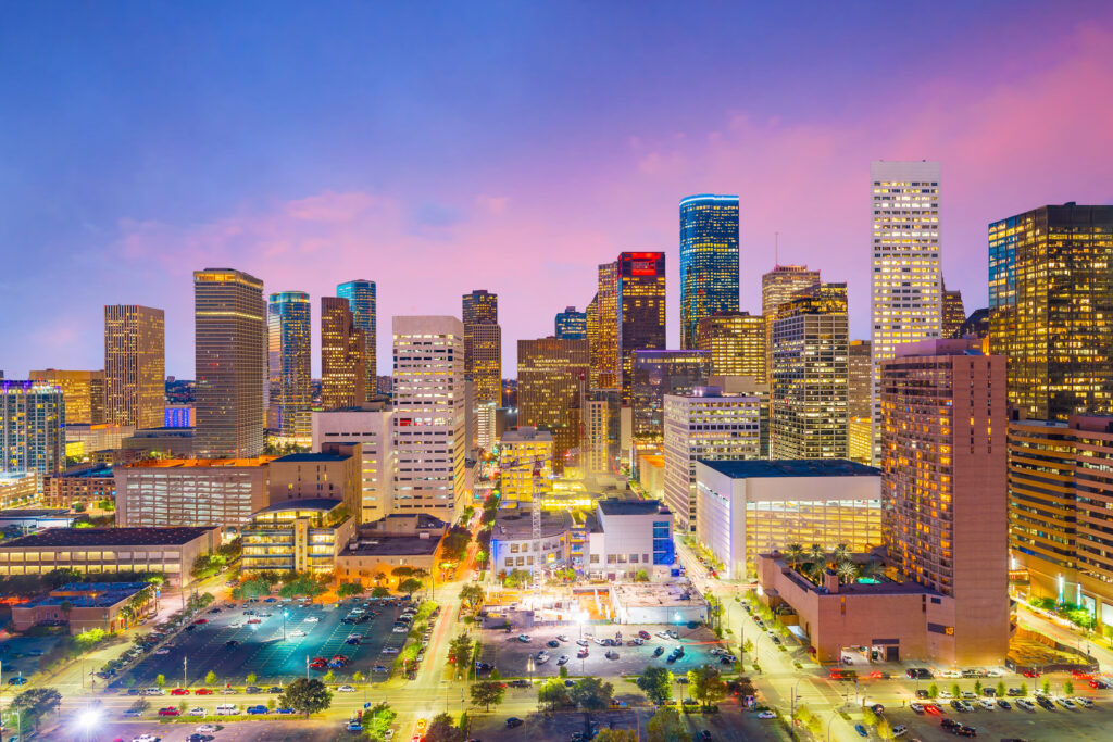Twilight view of a bustling Houston cityscape with illuminated skyscrapers. 