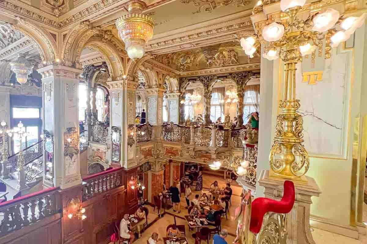 The interior of an ornate building in Budapest, Hungary, with people in it.