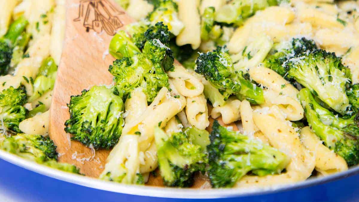 A close up image of a pan of Cavatelli and Broccoli with a serving spoon.