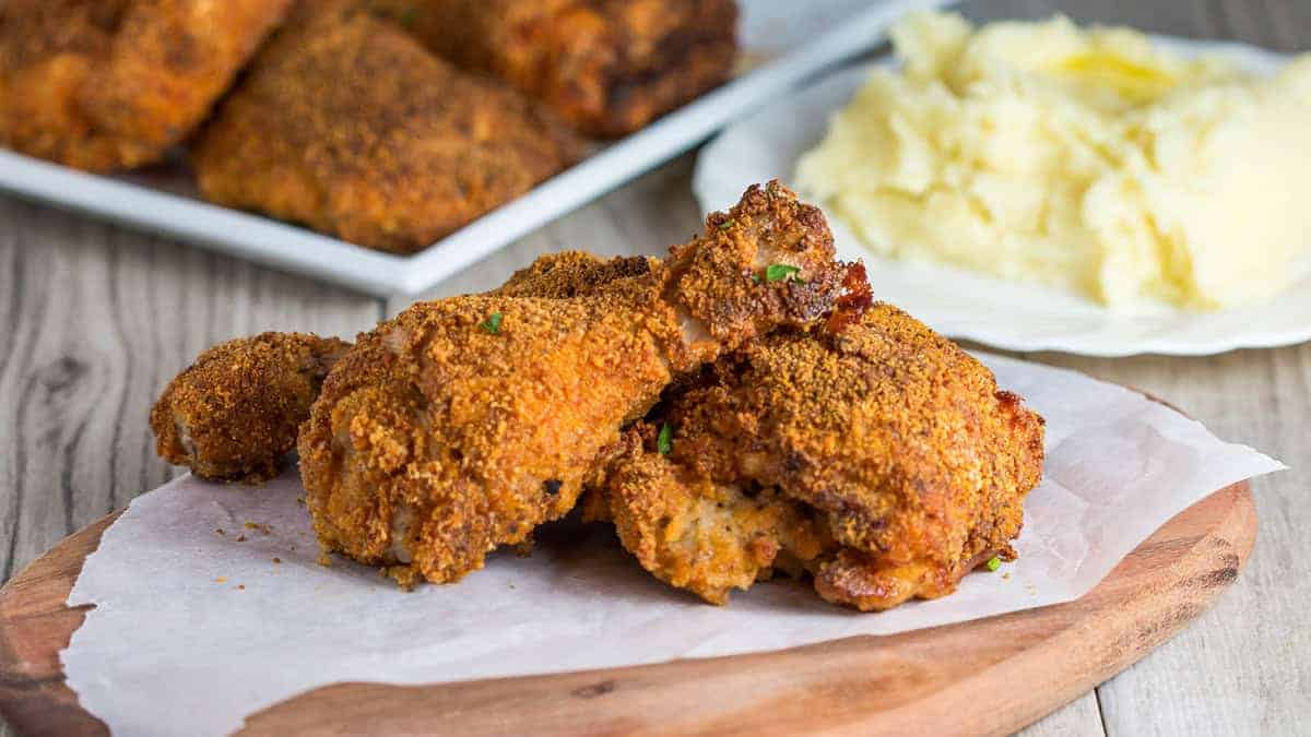 Three pieces of Easy Oven Fried Chicken speckled with parsley.