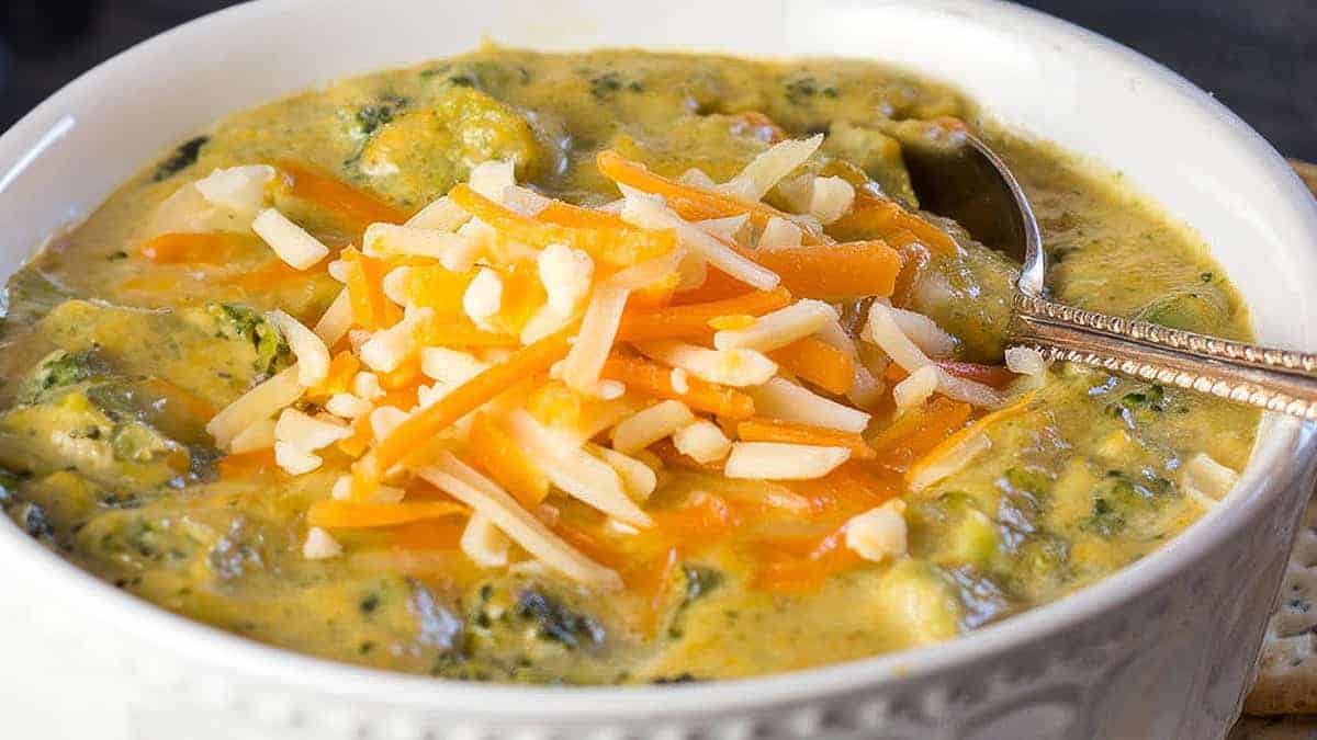 a close up image of Low Carb Broccoli Cheese Soup topped with extra cheese.