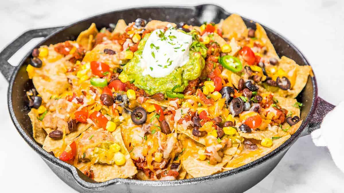Hot nachos fresh from the oven topped with guacamole and sour cream.