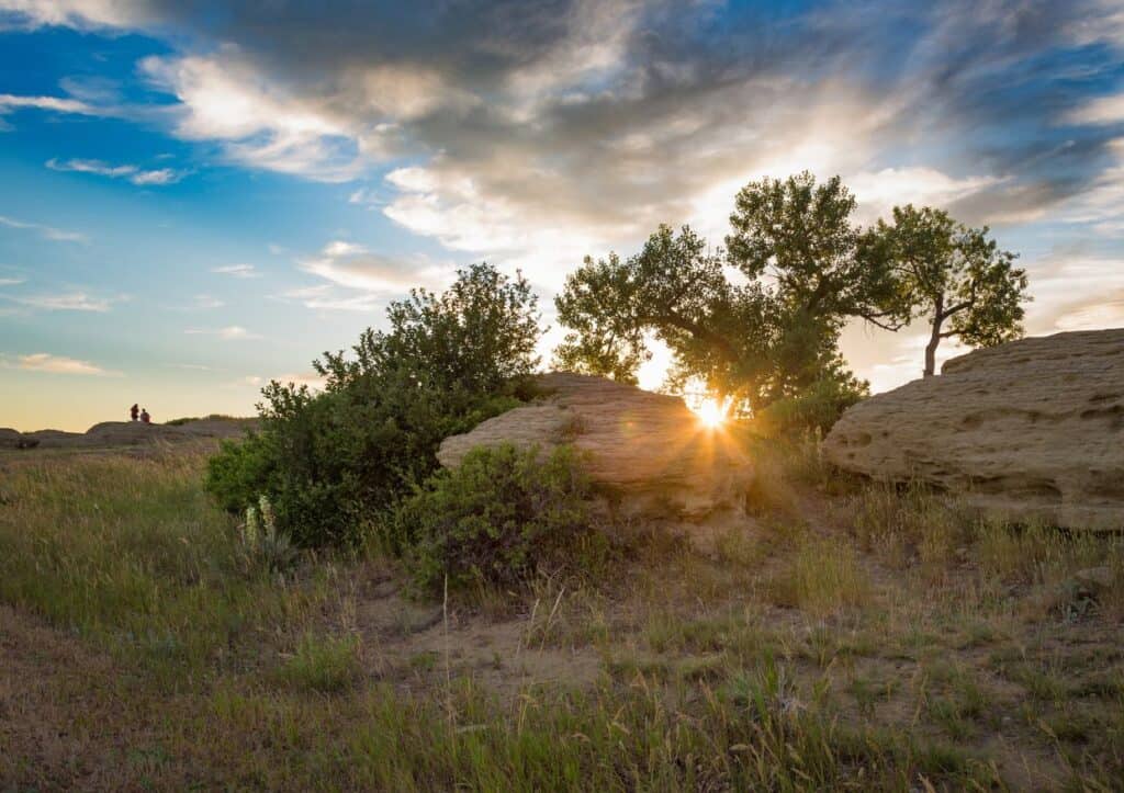 The setting sun slips behind a rocky bluff at sunset.