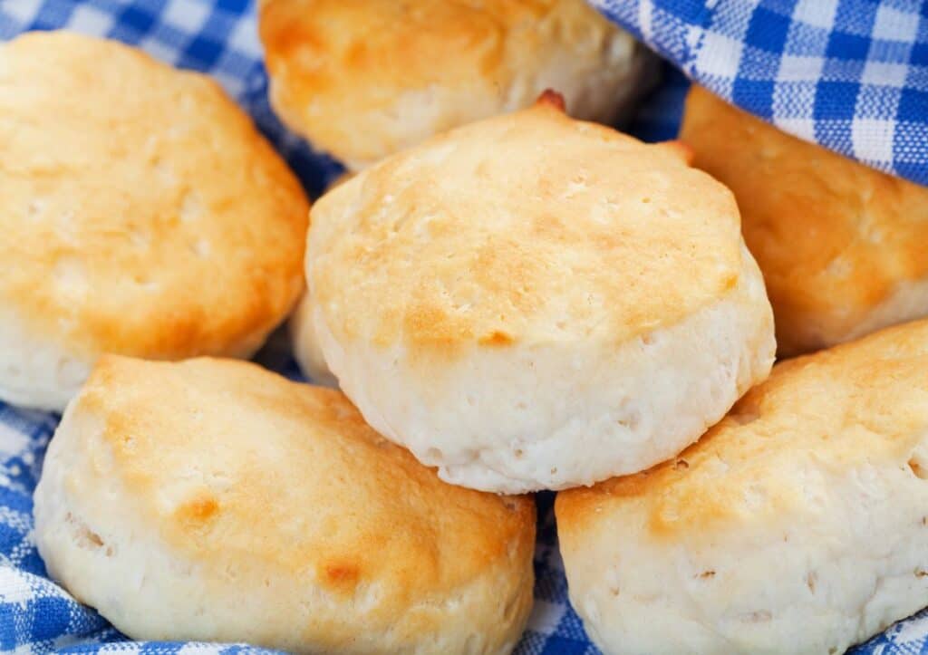 Buttermilk biscuits served on a blue and white checkered napkin.