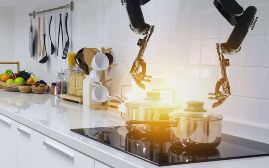 A kitchen with robotic arms cooking on a stove. Cooking utensils and food items are organized on the countertop and wall.