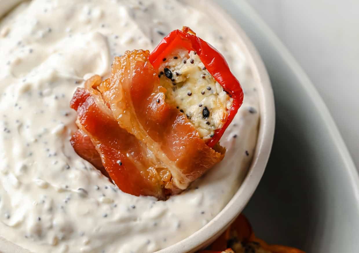 One bacon wrapped mini peppers dipped in Everything Bagel dip.