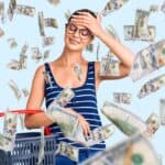 A person wearing glasses and a striped shirt smiles while holding a shopping basket, as hundred-dollar bills rain down around them.