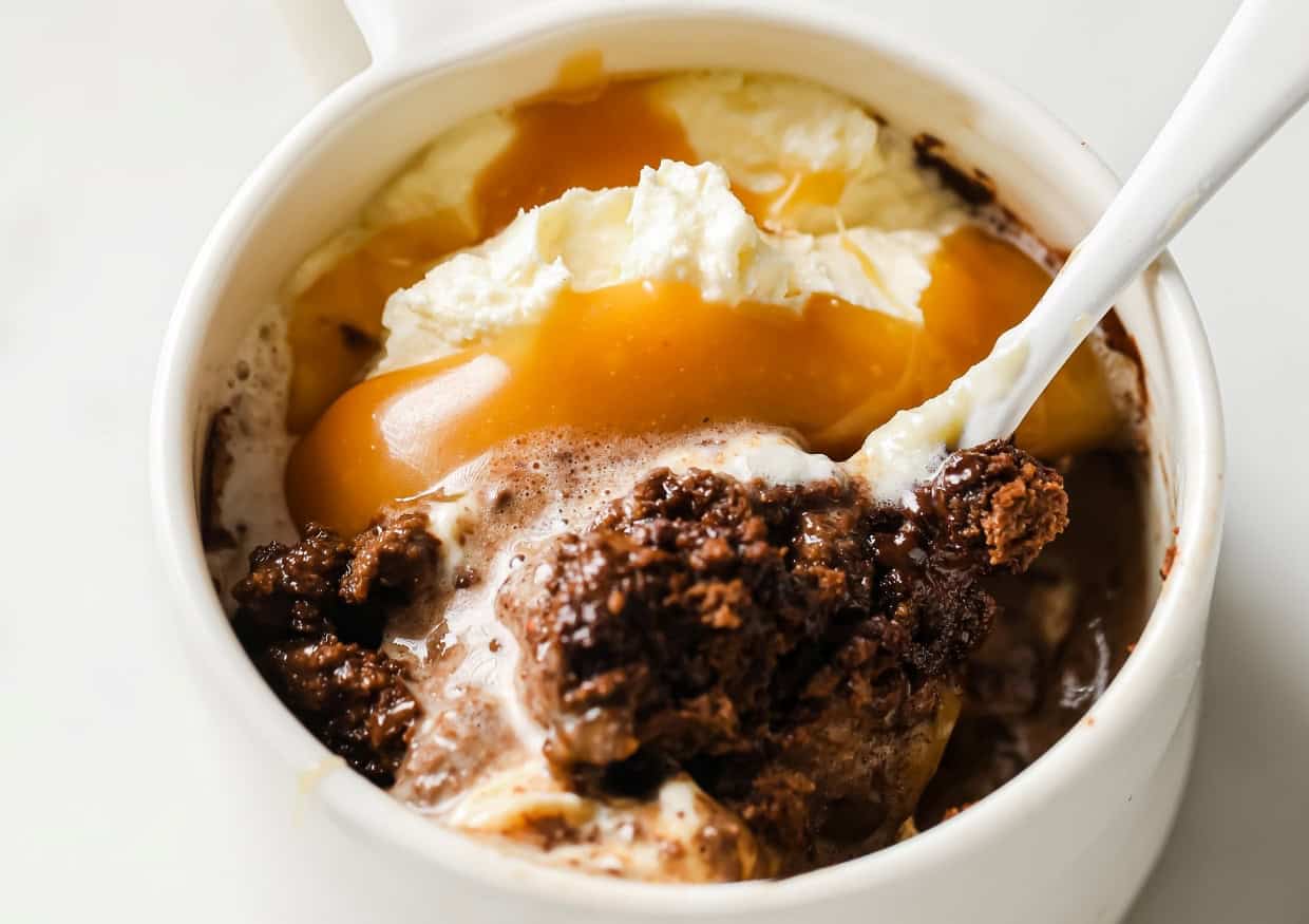 Low-carb double chocolate mug cake with ice cream and caramel in a mug.