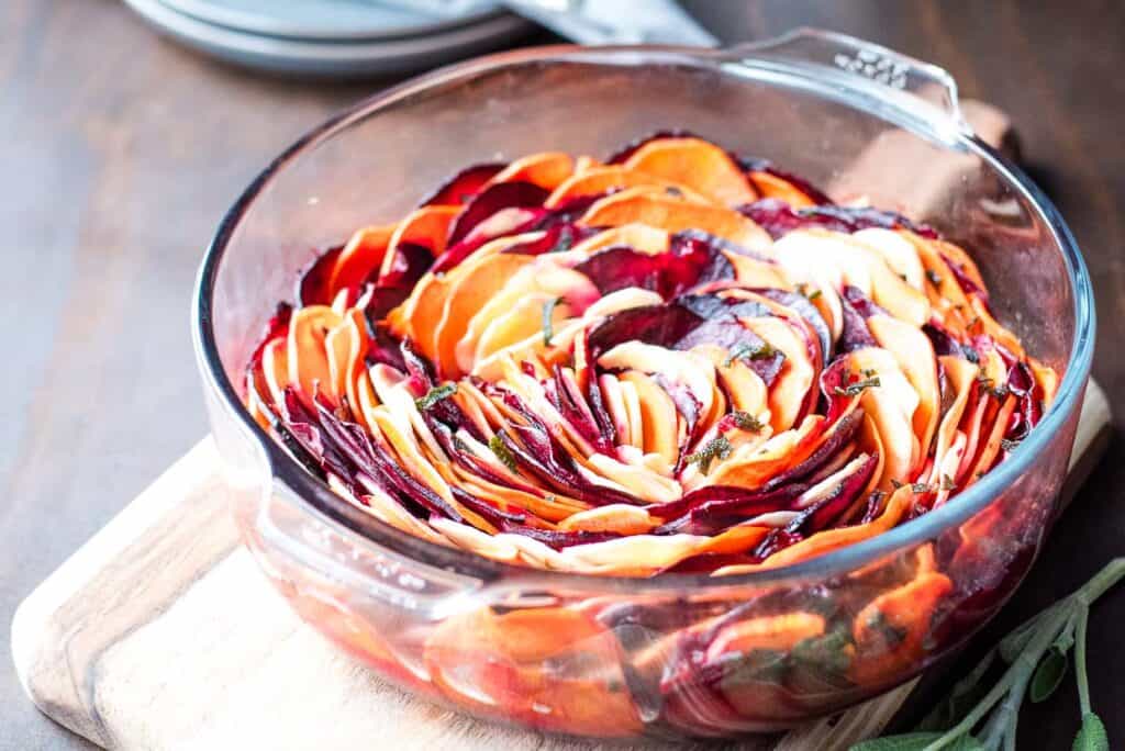 A colorful spiral of sliced root vegetables arranged in a bowl.