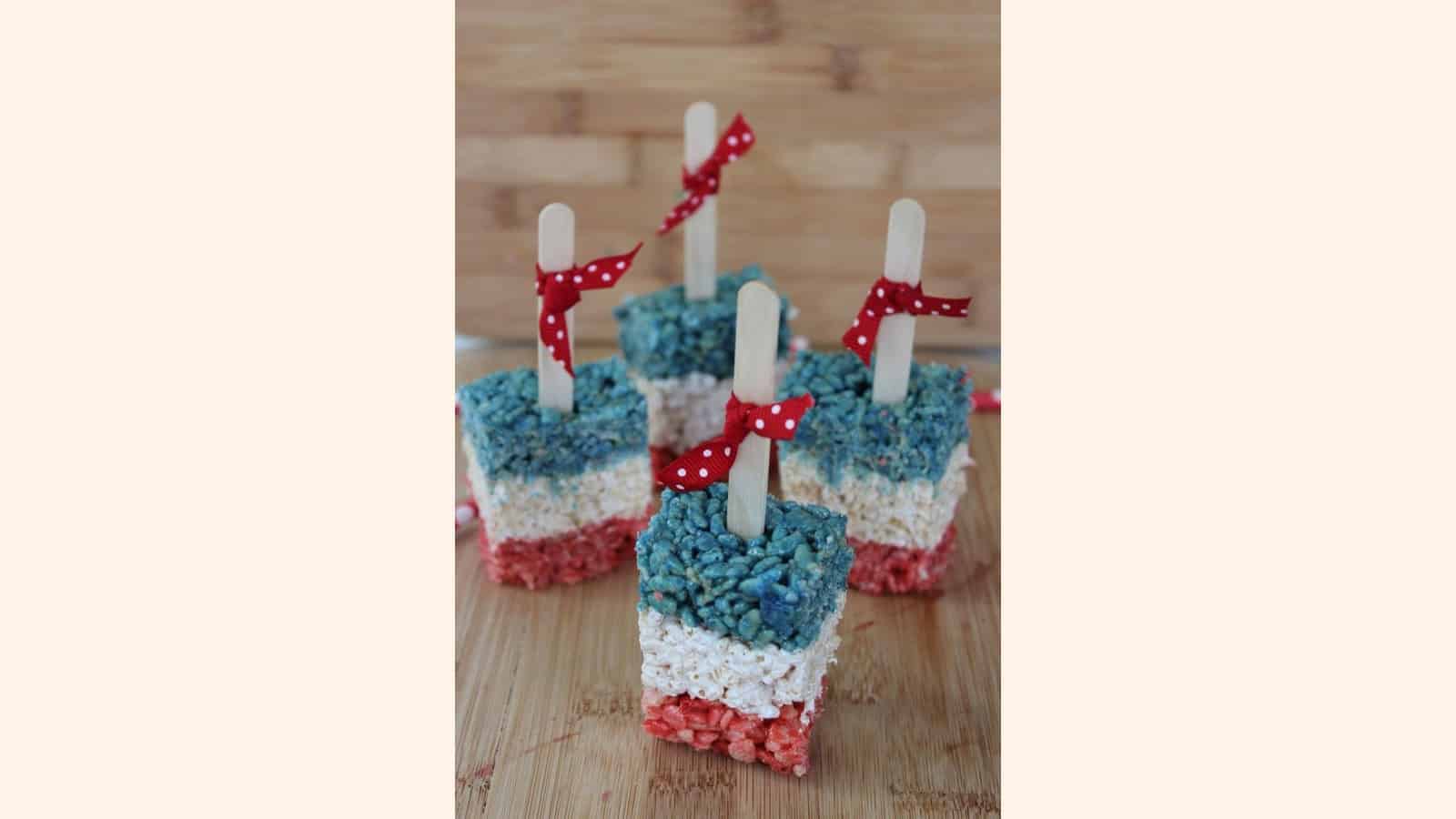Four red white and blue rice krispie tops with a red ribbon.