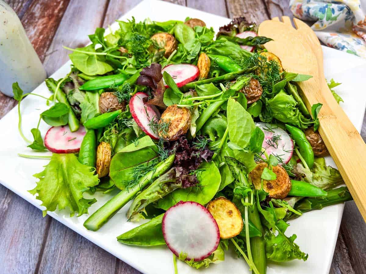 Spring salad with asparagus and potatoes on a white plate.