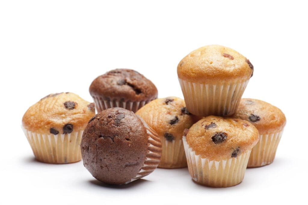 A group of seven muffins, some chocolate and some with visible chocolate chips, arranged on a white background.