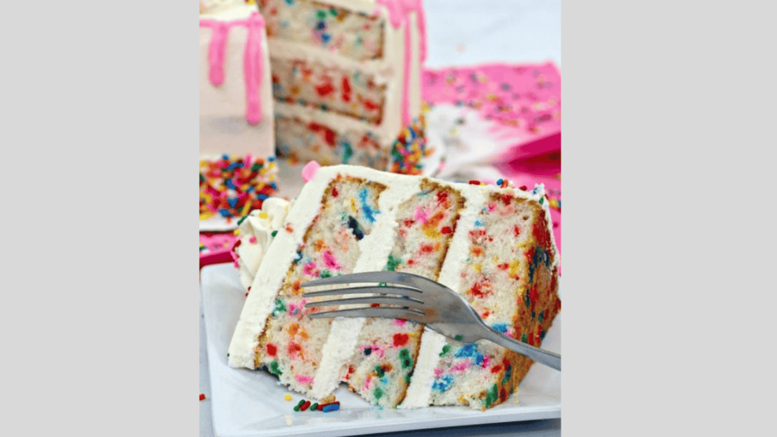 A fork cutting into a 3 layered funfetti cake with vanilla buttercream.