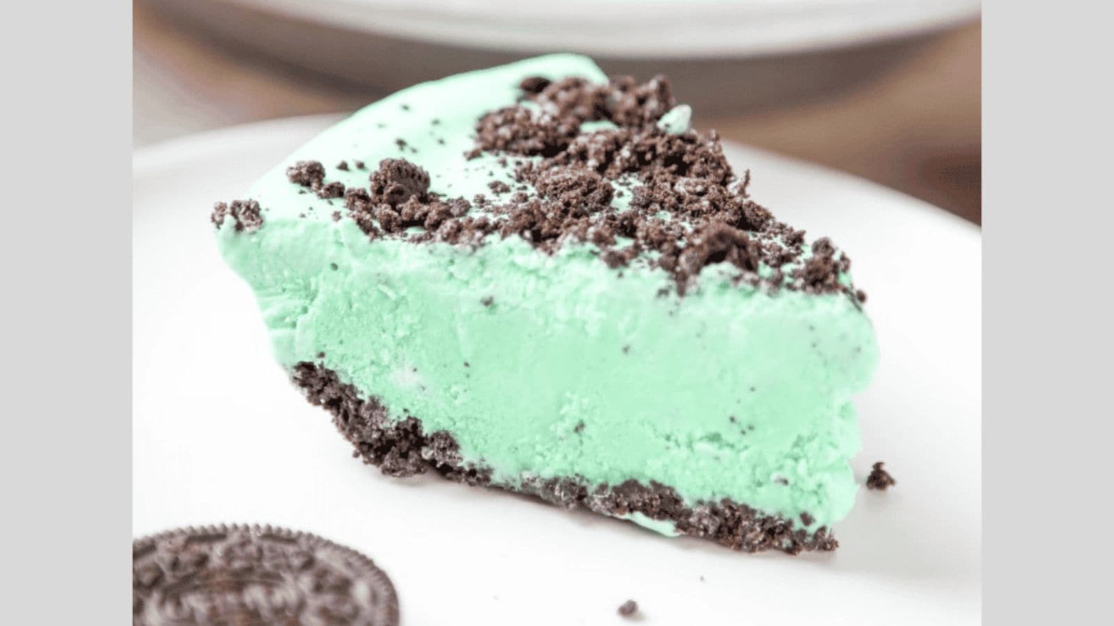 A mint pie inside an oreo crust topped with oreo crumbs.