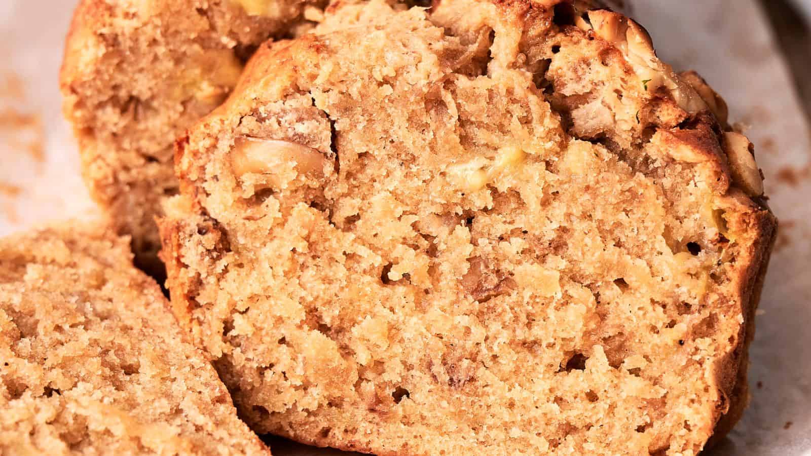 Close-up of a sliced banana bread loaf, showcasing its moist, textured interior with visible banana chunks.