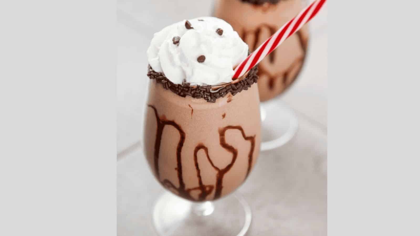 A mudslide drink topped with whipped cream, chocolate chips, and sprinkles.