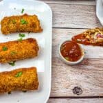 A hand is holding half of the Redneck Eggrolls, with pieces on a white plate.