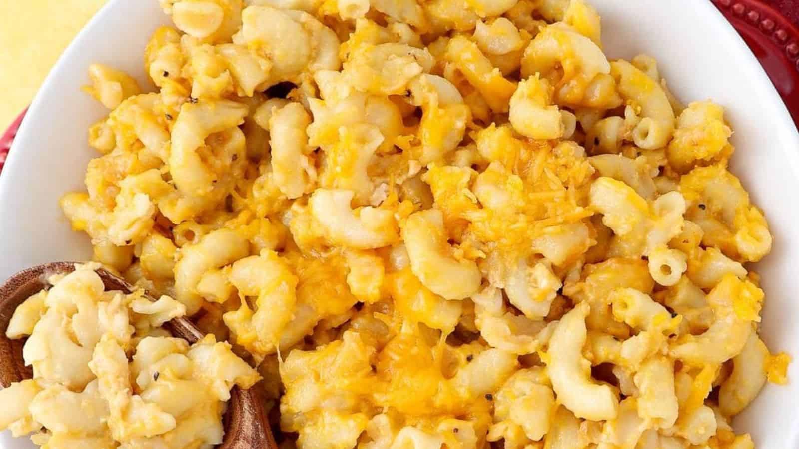 A slow cooker filled with mac and cheese with a gooey, cheesy topping.