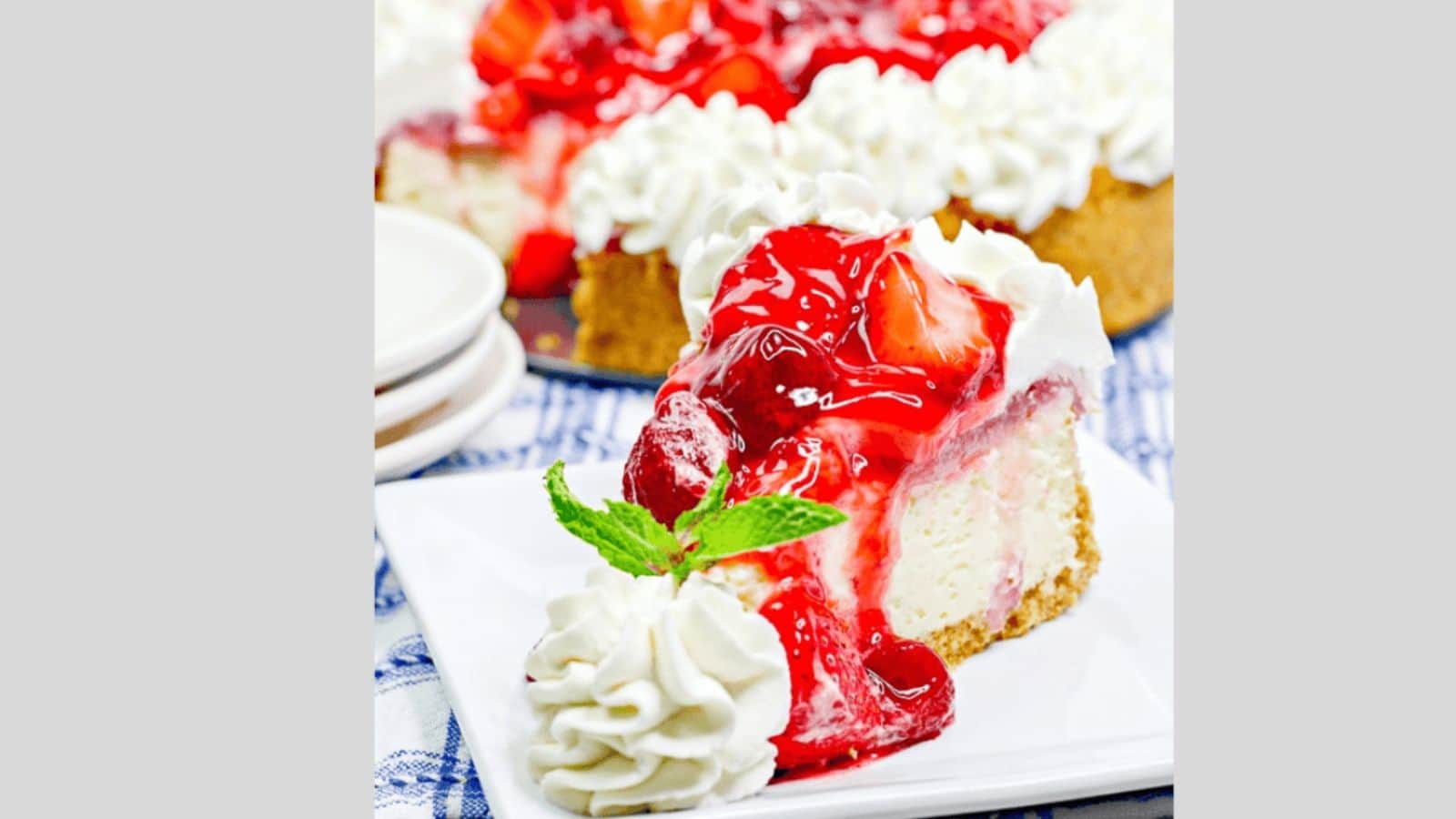 Cheesecake topped with strawberries and whipped cream.