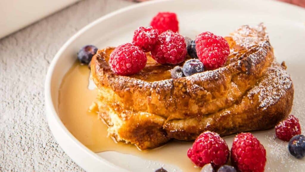French toast bake with berries on a white plate.
