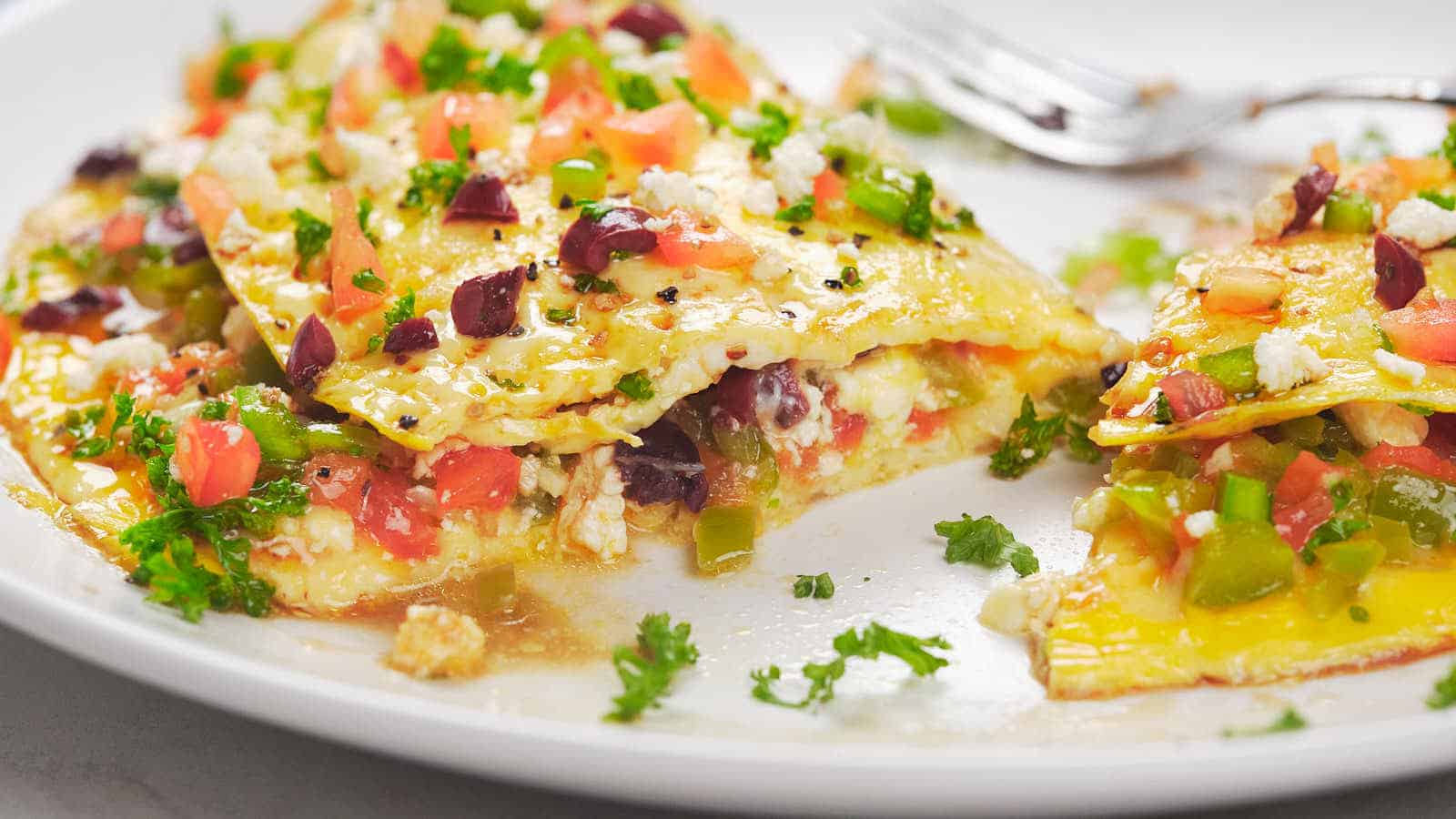 A plated serving of Mediterranean omelet filled with various ingredients.