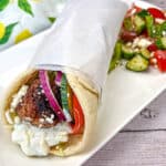 Greek Meatball Pita Sandwich served on a white rectangular plate.