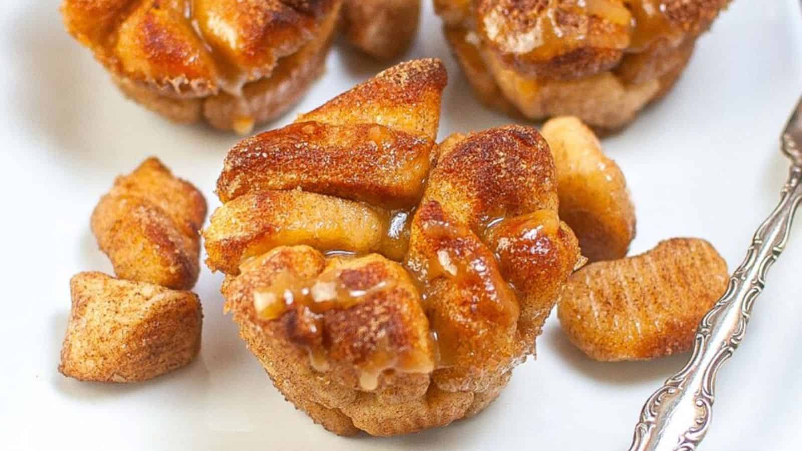 Sweet, glazed monkey bread pieces served in a white bowl, drizzled with icing.