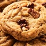 Close-up of several freshly baked cookies with chunks of nuts on top.