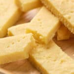 A close-up of several rectangular pieces of shortbread placed on a wooden surface.