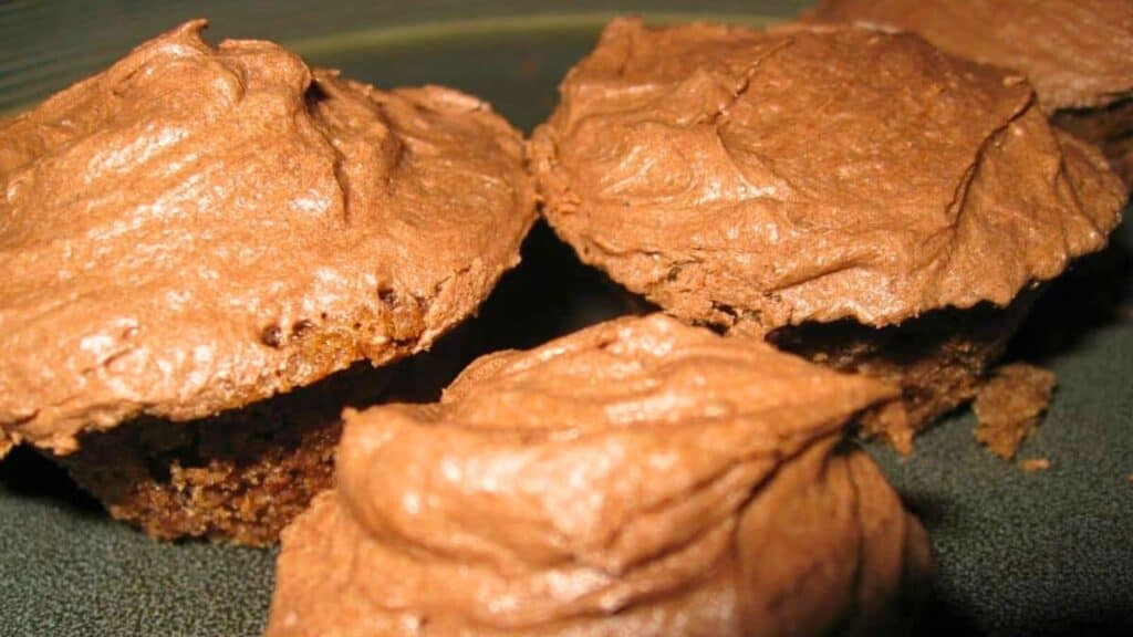 Close-up of chocolate cupcakes with chocolate frosting on a plate.