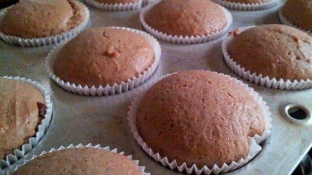 Tray of freshly baked nutella yogurt cupcakes in paper liners.