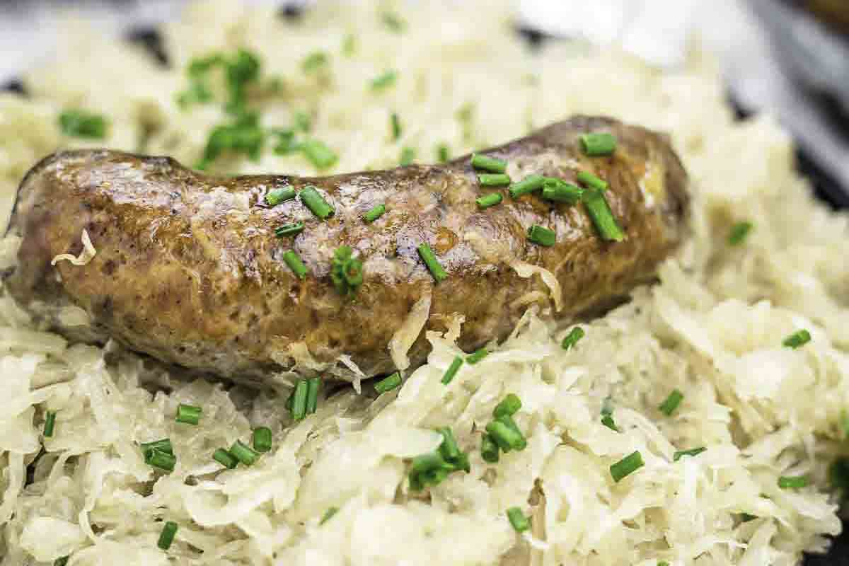 A cooked sausage on a sauerkraut plate.