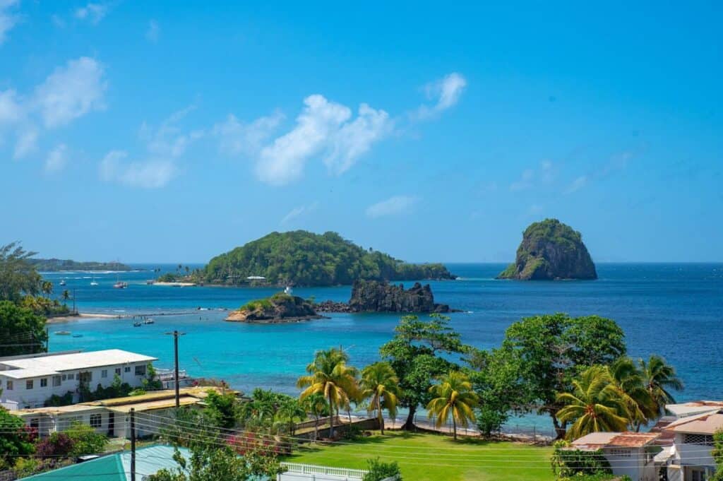 A coastal view featuring turquoise waters, small islands, and lush greenery under a clear blue sky—a perfect setting for wellness retreats in the Caribbean.