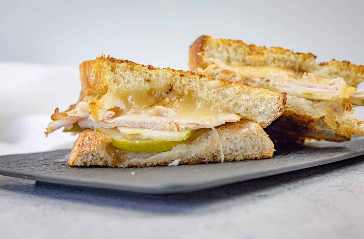 A close-up of a sliced Turkey & Apple Grilled Cheese on a plate.