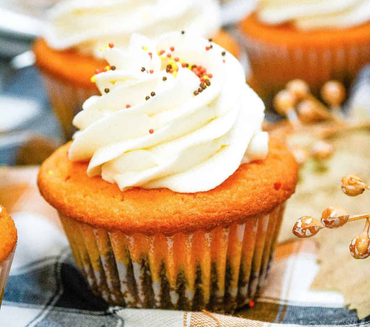 Fall brownie cupcakes with whipped cream on a plate.