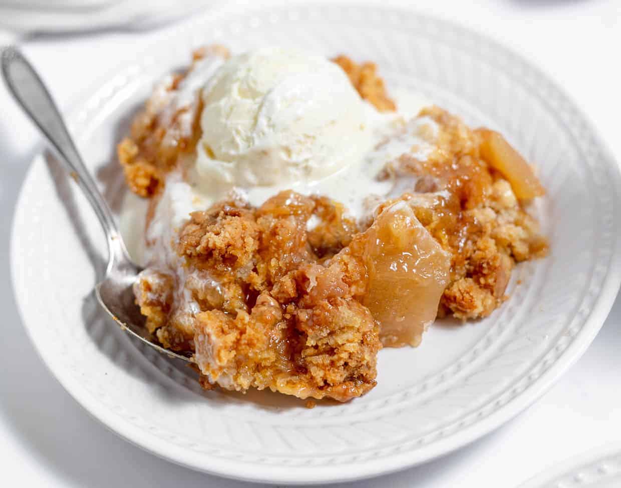 A bowl of cake with ice cream on top.