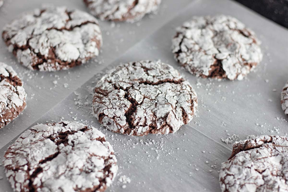 A cookie sheet with chocolate cookeis on it.