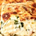 Close-up of a slice of creamy vegetable lasagna with a golden-brown cheese crust.