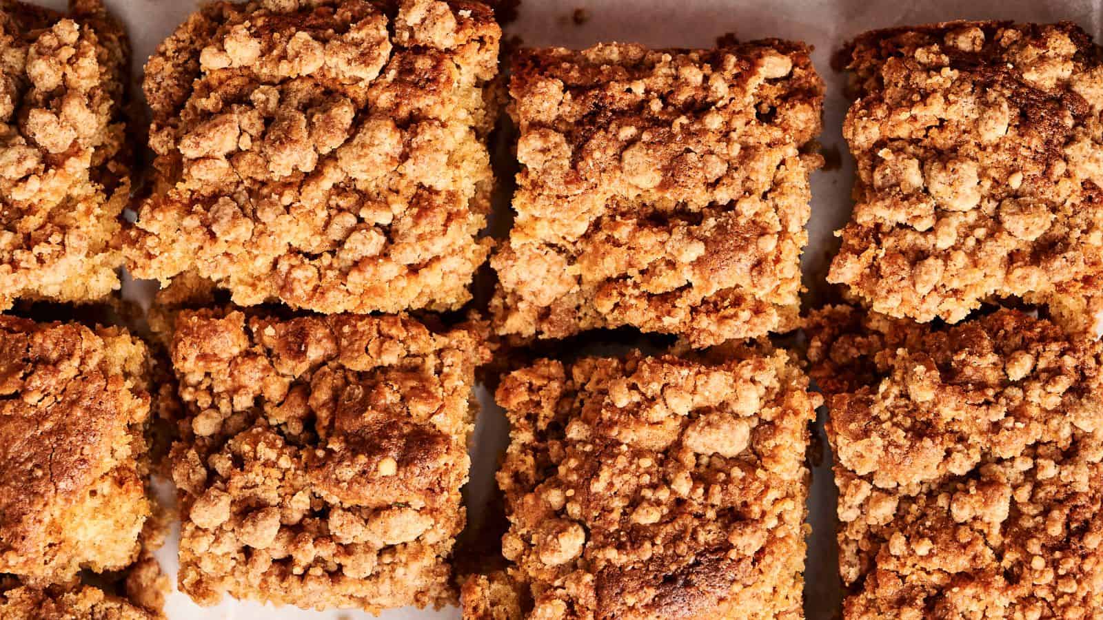 Close-up of eight square pieces of crumb cake with a textured, crumbly topping.