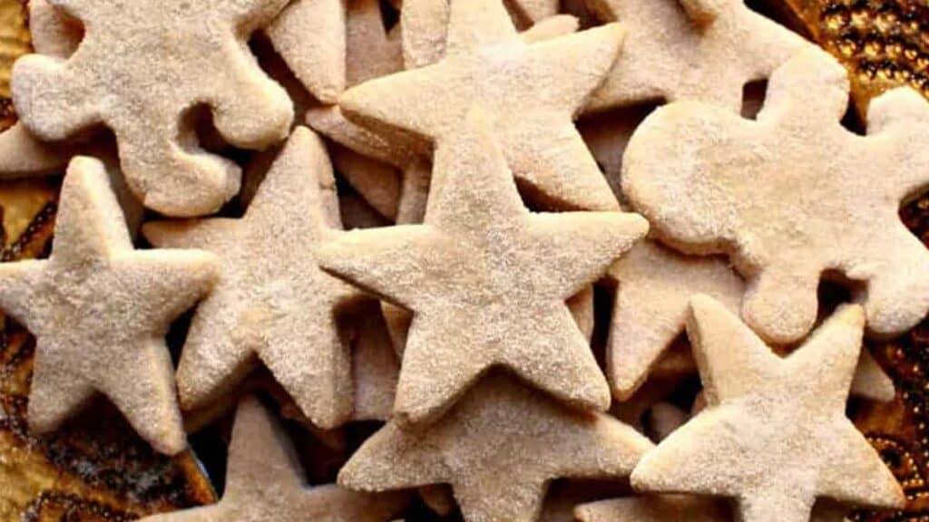 A pile of star- and person-shaped cookies dusted with powdered sugar.