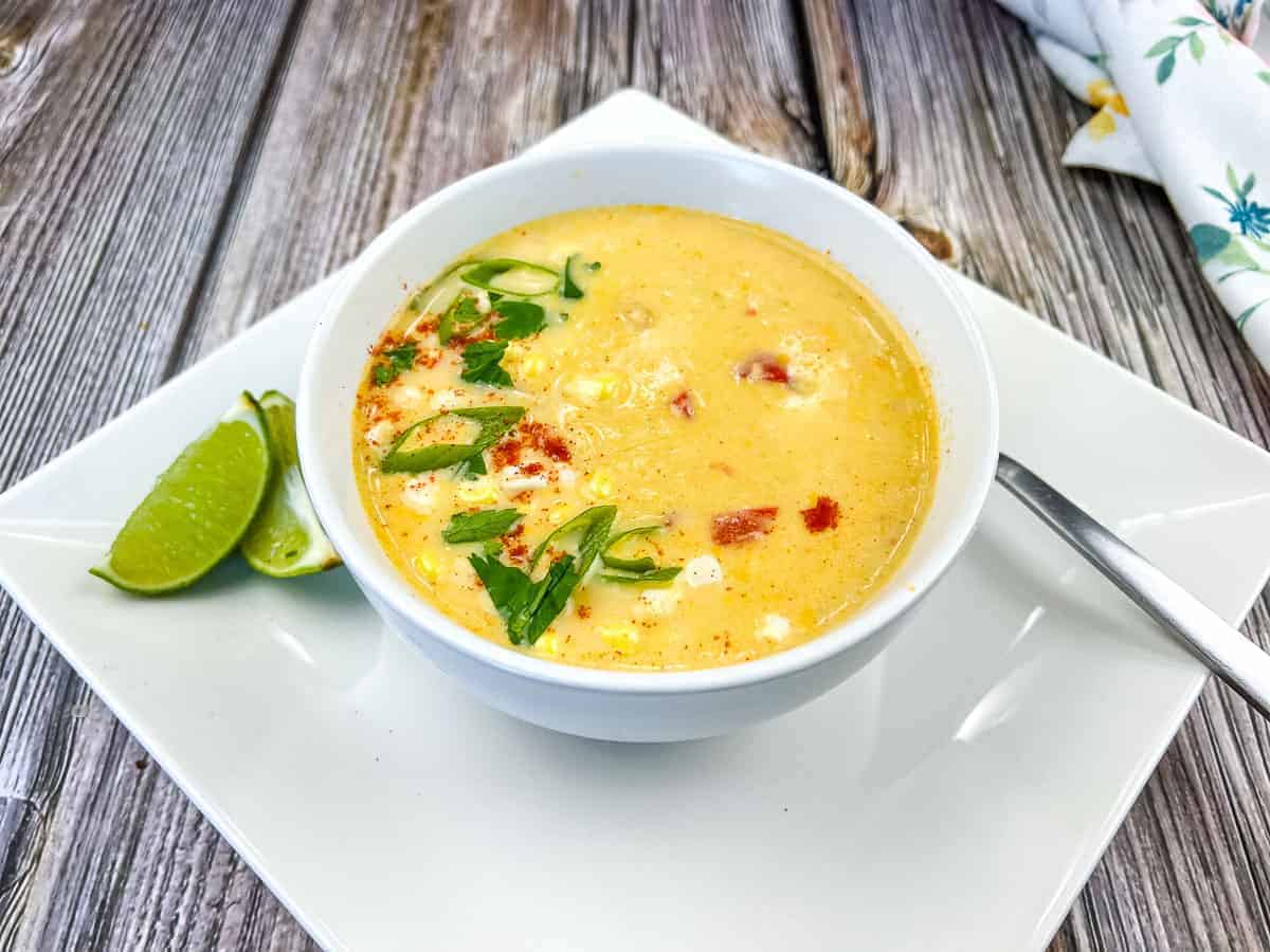 A bowl of Panera Bread’s Street Corn Soup with herbs and spices on top.