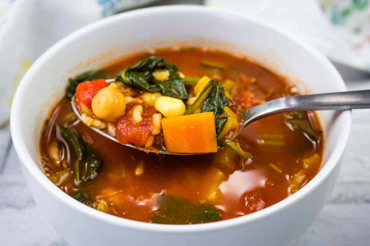 A spoonful of Copycat Panera Bread’s 10 Vegetable soup from a white bowl.