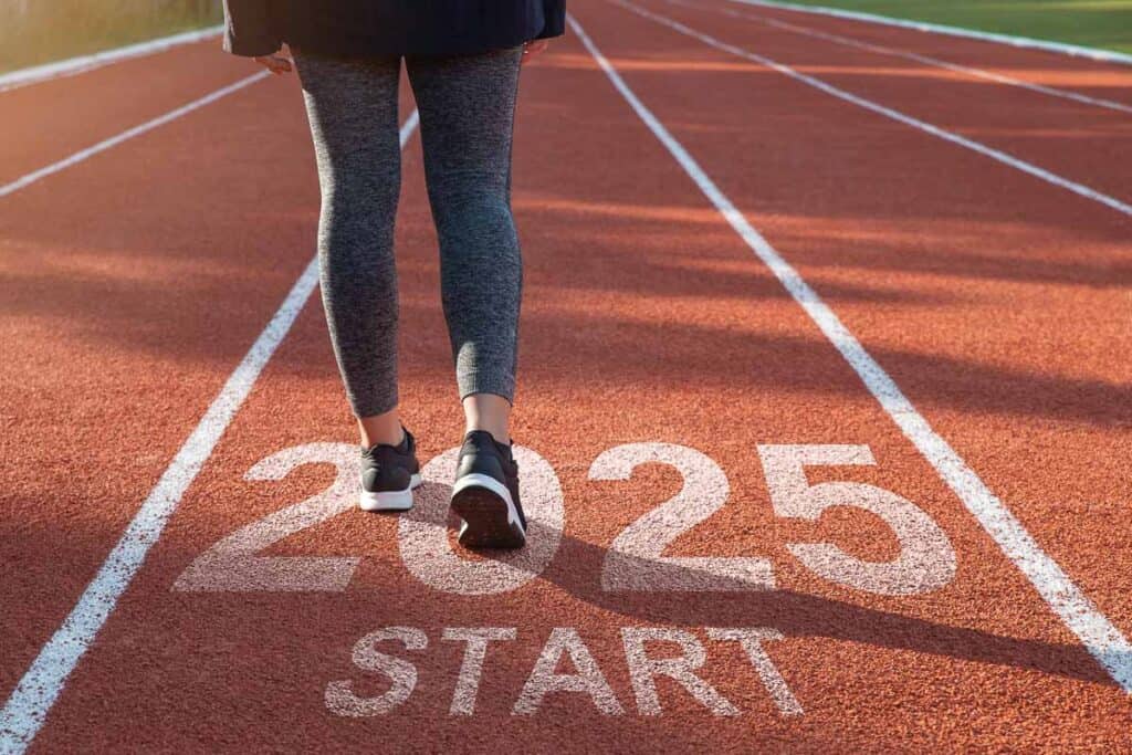 Person walking on a track with "2025 START" painted on it, symbolizing a new beginning or future goal.